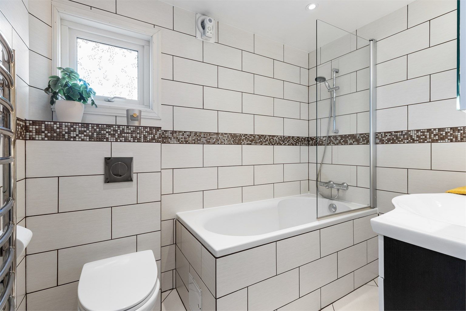 Badet i første etasje er helfliset og utstyrt med badekar, vegghengt toalett og gulvvarme.