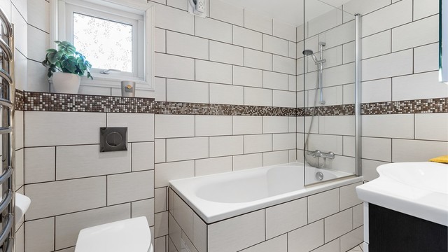 Badet i første etasje er helfliset og utstyrt med badekar, vegghengt toalett og gulvvarme.