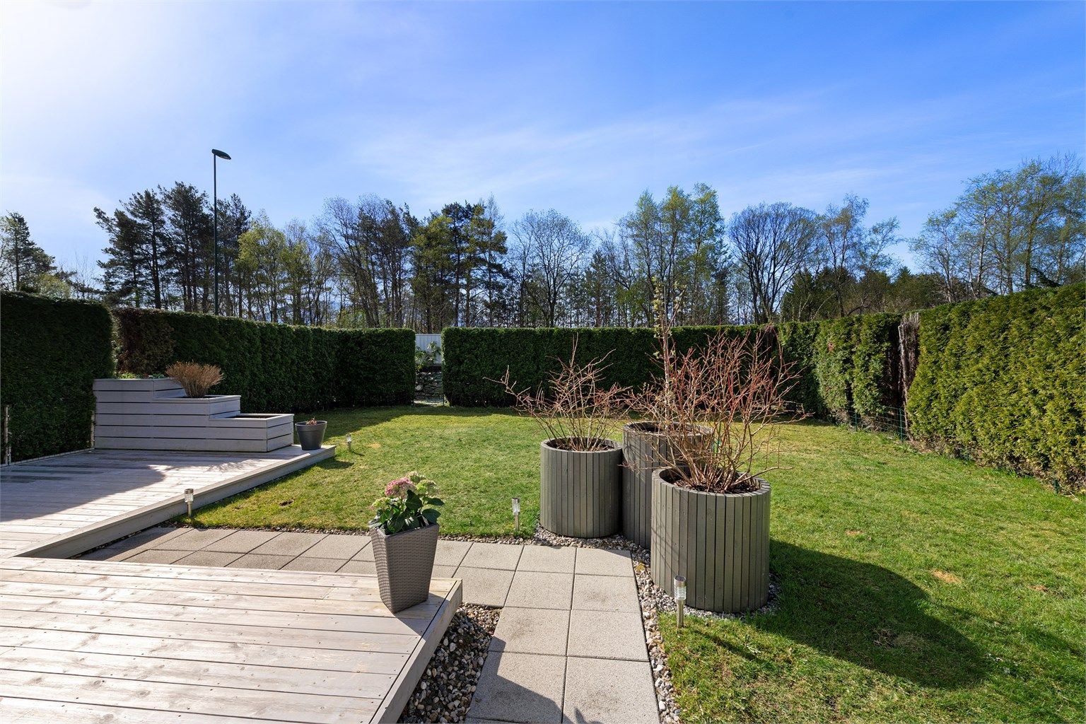 Terrassen går over i en flat og lettstelt hage, perfekt for lek og sosiale sammenkomster.