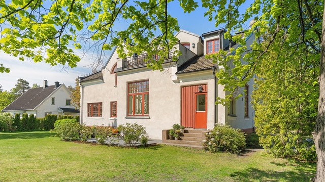 Eiendommen ligger i et ærverdig murbygg fra 1898, tilbaketrukket på en stor, grønn tomt.