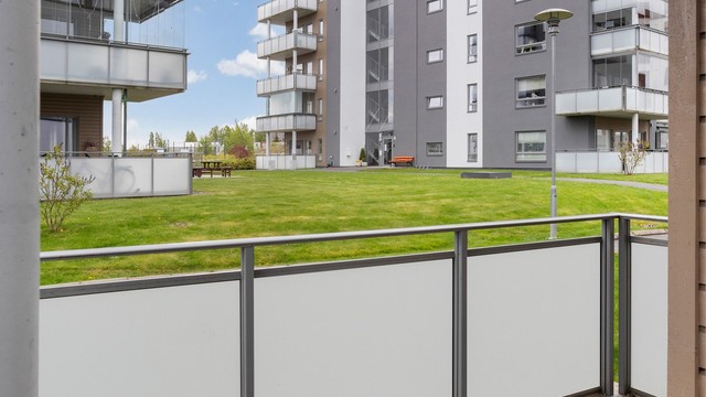 Fra uteplassen er det utsikt over sameiets fellesarealer med gressplen og beplantning.