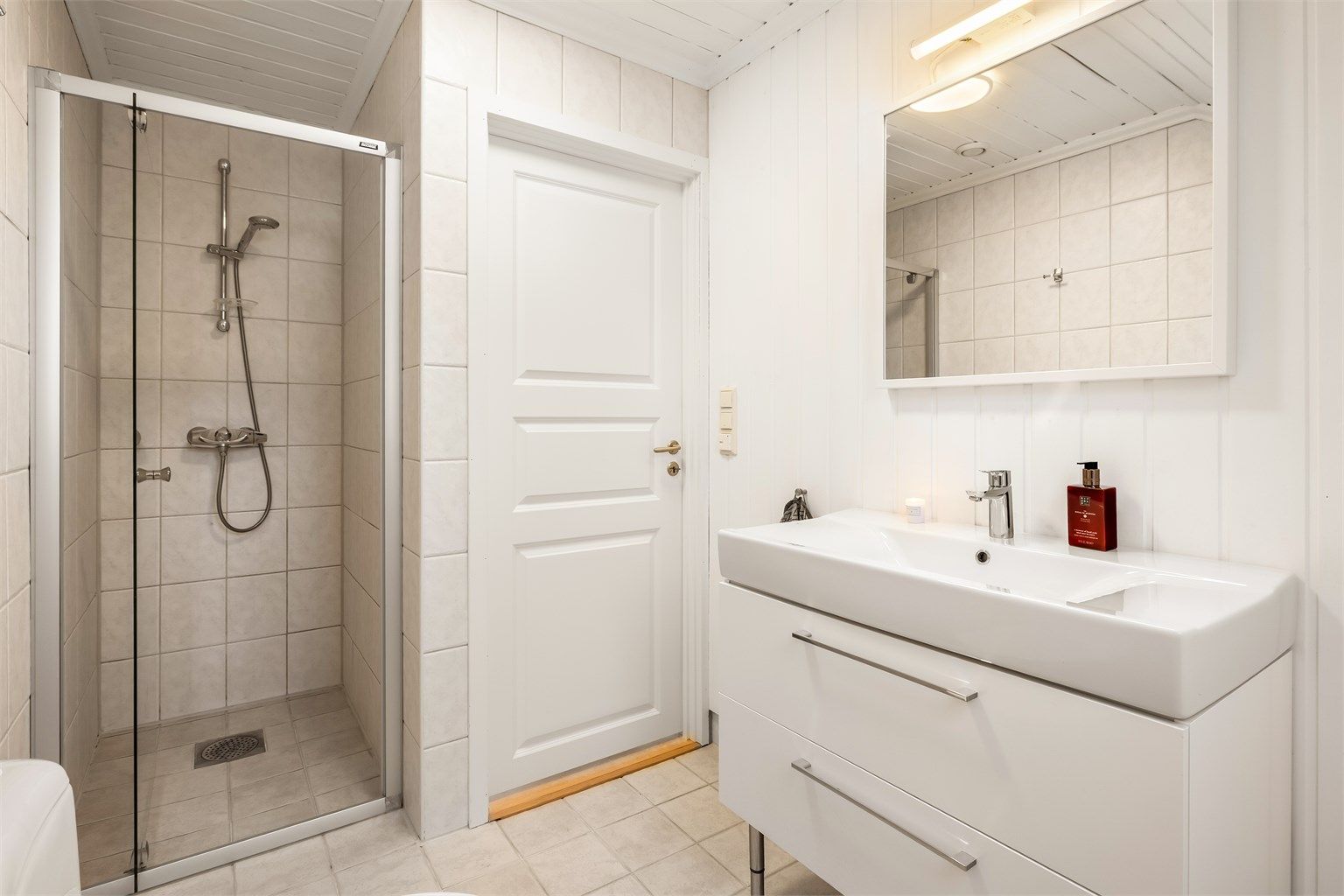 Rommet er utstyrt med dusjhjørne med innfellbare vegger, toalett og servantinnredning.