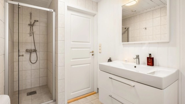 Rommet er utstyrt med dusjhjørne med innfellbare vegger, toalett og servantinnredning.