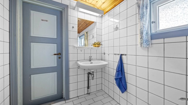 Rommet er utstyrt med servantinnredning, speil med belysning og toalett.