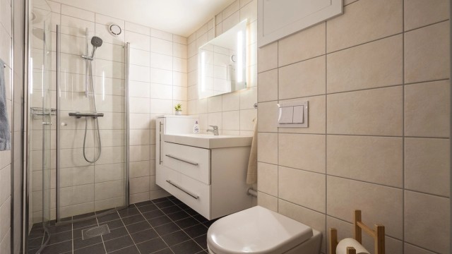 Badet er fra 2018 og er pent flislagt på gulv og vegger med varme i gulvet
