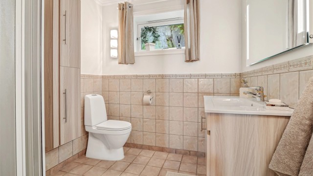 Badet i kjelleren er utstyrt med dusjhjørne med skyvedørsramme og har varmekabler i gulvet.