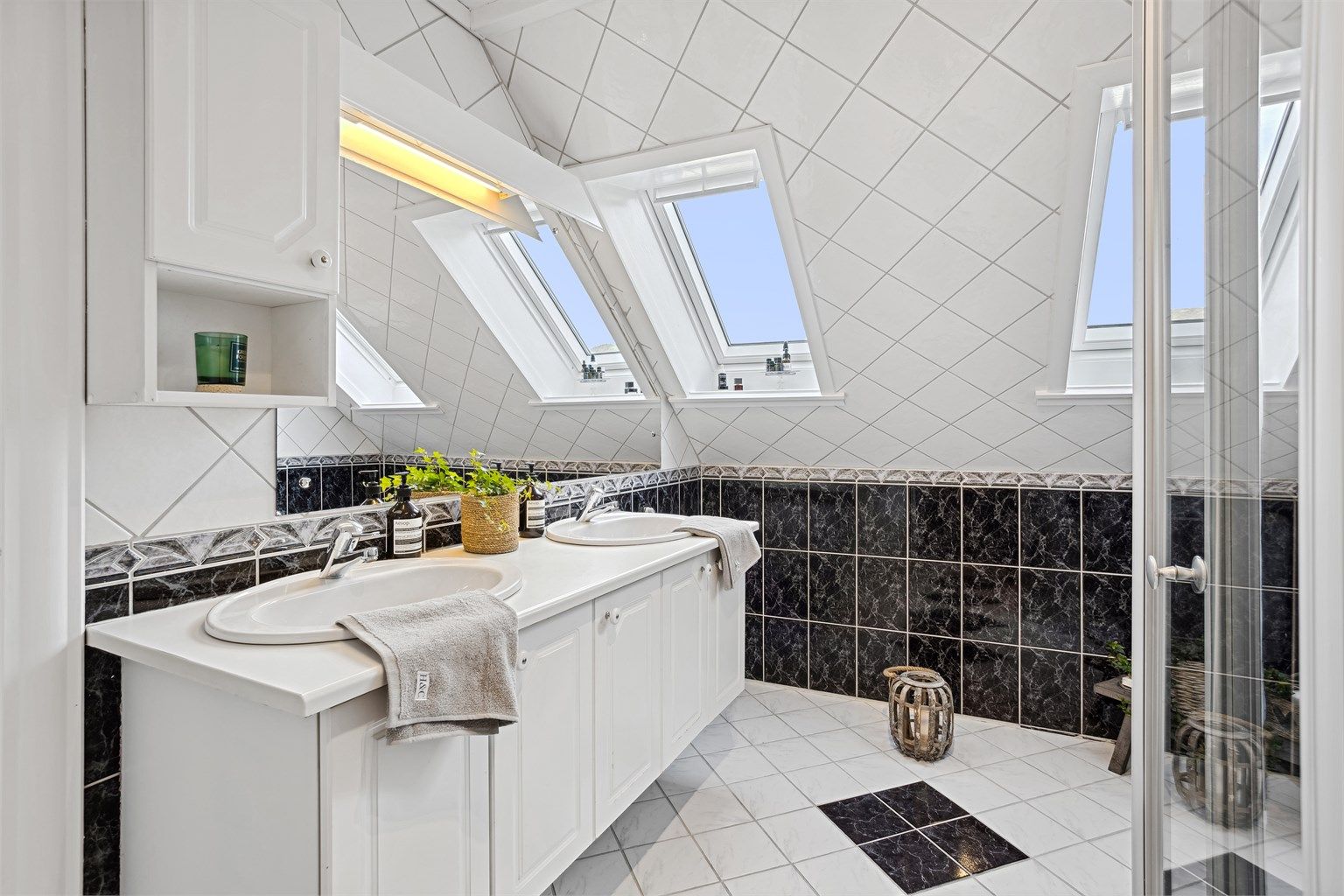 Romslig helfliset bad i loftsetasjen. Velux vinduer som gir godt med lysinnslipp.  