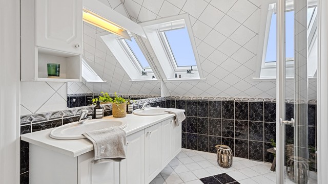 Romslig helfliset bad i loftsetasjen. Velux vinduer som gir godt med lysinnslipp.