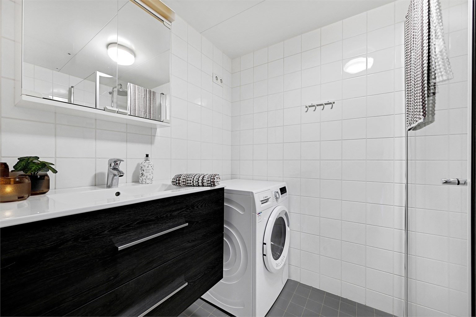 Det flislagte badet har opplegg for vaskemaskin og varmekabler i gulvet.
