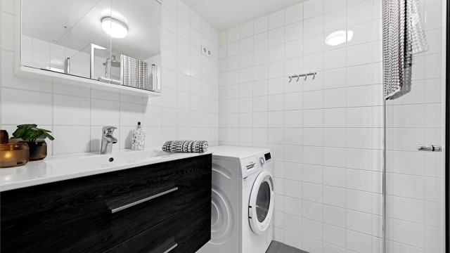 Det flislagte badet har opplegg for vaskemaskin og varmekabler i gulvet.