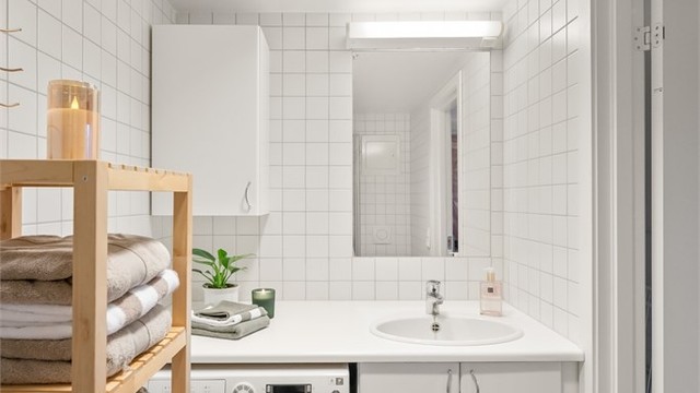 Servantseksjon med underskap, heldekkende benk og speil med belysning.
