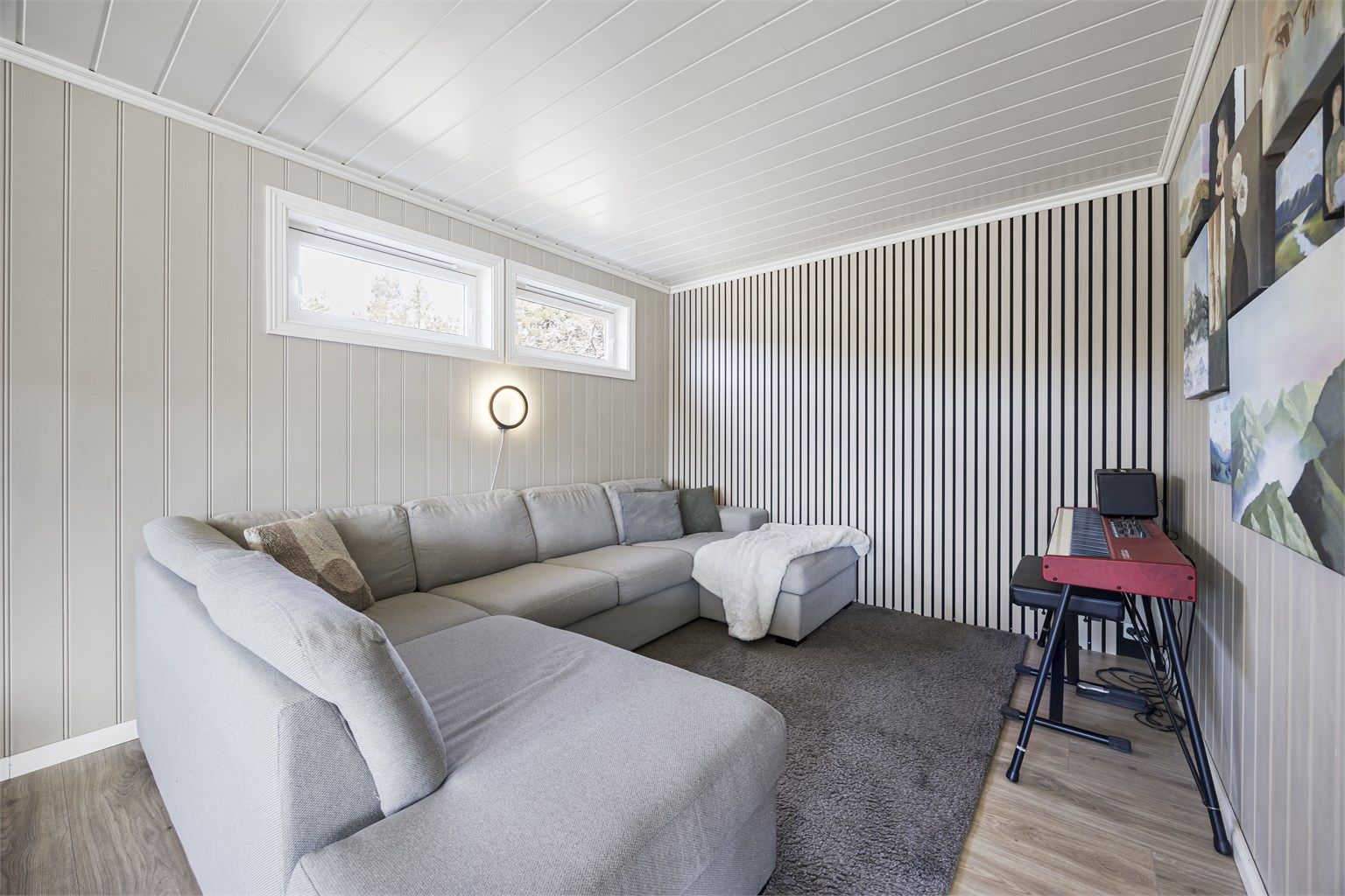 En del av stuen er innredet som en lun TV-krok, med en moderne spilevegg som et dekorativt element.