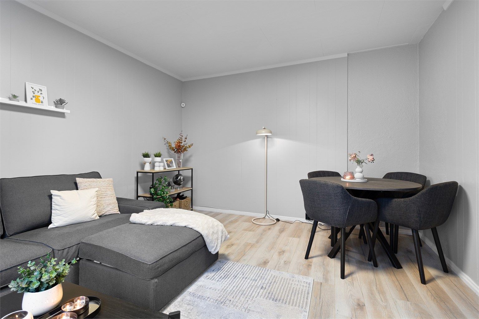 Gjennomgående laminatgulv og lyse veggflater gir et helhetlig inntrykk.