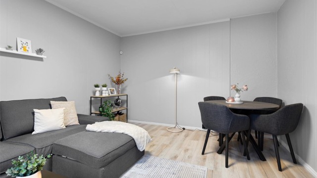 Gjennomgående laminatgulv og lyse veggflater gir et helhetlig inntrykk.