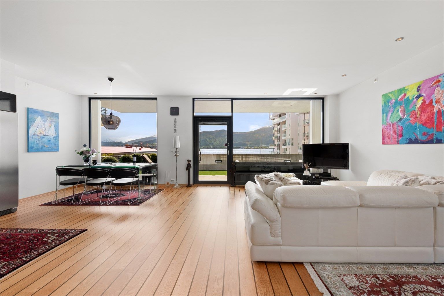 Stue og kjøkken i åpen løsning med store vindusflater mot syd som gir godt med naturlig lysinnslipp