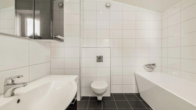 Rommet har flislagt gulv med vannbåren varme og vegghengt toalett.
