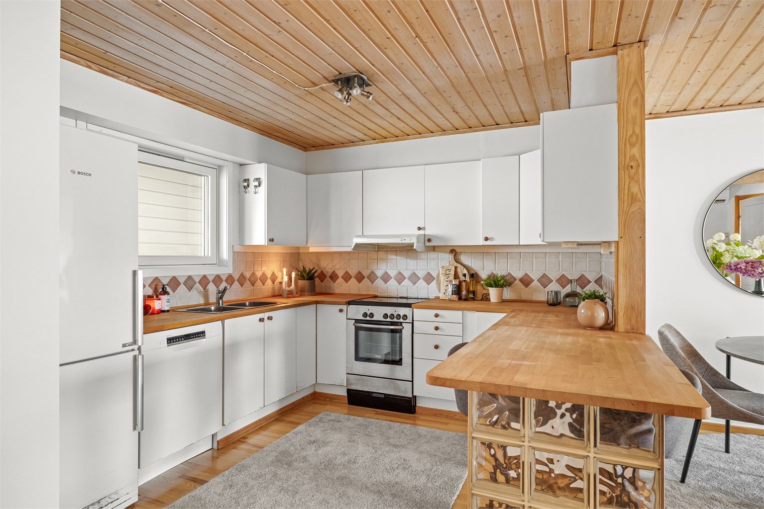 Den praktiske barløsningen fungerer som en naturlig romdeler og en hyggelig plass for raske måltider.