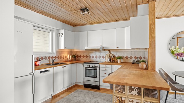 Den praktiske barløsningen fungerer som en naturlig romdeler og en hyggelig plass for raske måltider.