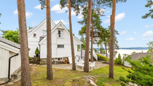 Solrik og usjenert tomt med fjordutsikt, som er pent opparbeidet med bl.a. plenareal, beplantning og noe naturtomt