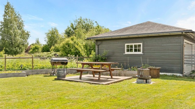 I hagen er det en egen platting for grilling og utemøbler. Den frittstående garasjen er isolert og har installert elbil-lader.