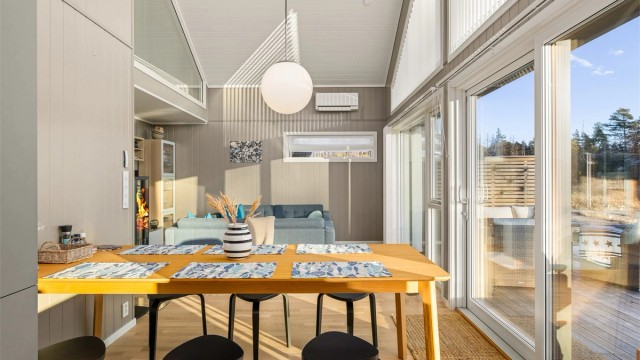 INNE ELLER UTE: Mot sjøen åpner allrommet seg opp med store vinduer fra gulv til tak. Terrassen utenfor har samme gulvnivå som stuen. Med åpne dører viskes overgangen mellom inne og ute bort, samtidig som det gir økt romfølelse.
