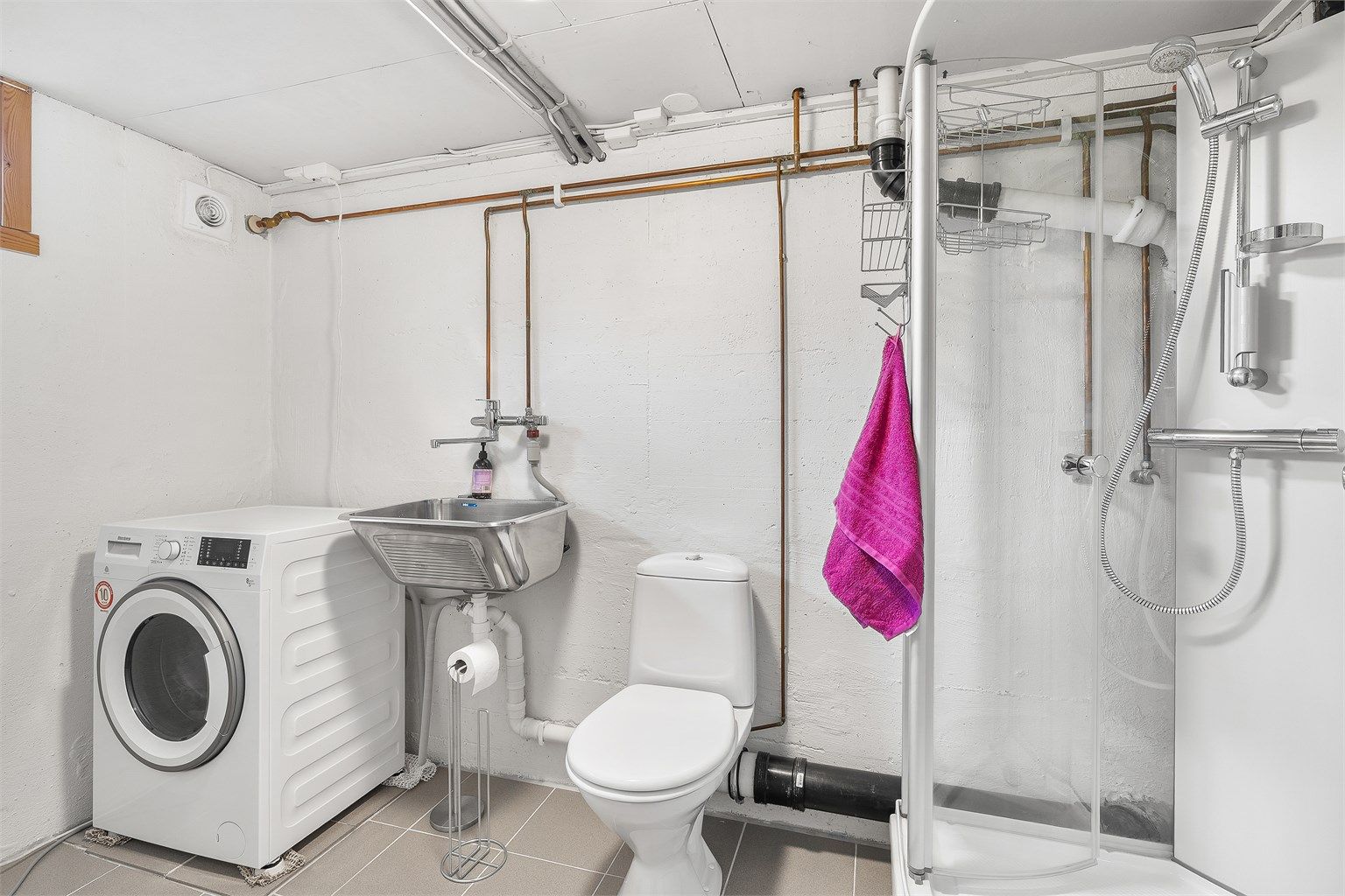 Flislagt bad i underetasje. Gulv med gulvvarme. Vegger og himling i malte flater