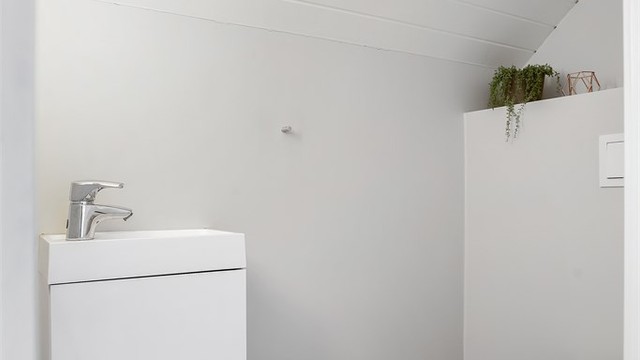 Praktisk toalettrom i andre etasje, utstyrt med vegghengt toalett og servantskap.