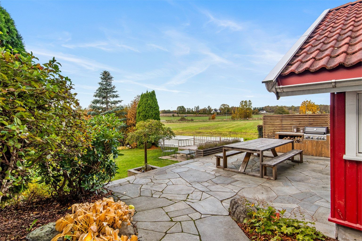 Den store plattingen er belagt med skiferheller og har god plass til flere sittegrupper. ( bilde fra i høst )