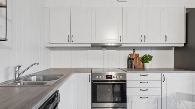 Kjøkkenet ligger i tilknytning til stuen og har en praktisk innredning med profilerte fronter og laminert benkeplate.