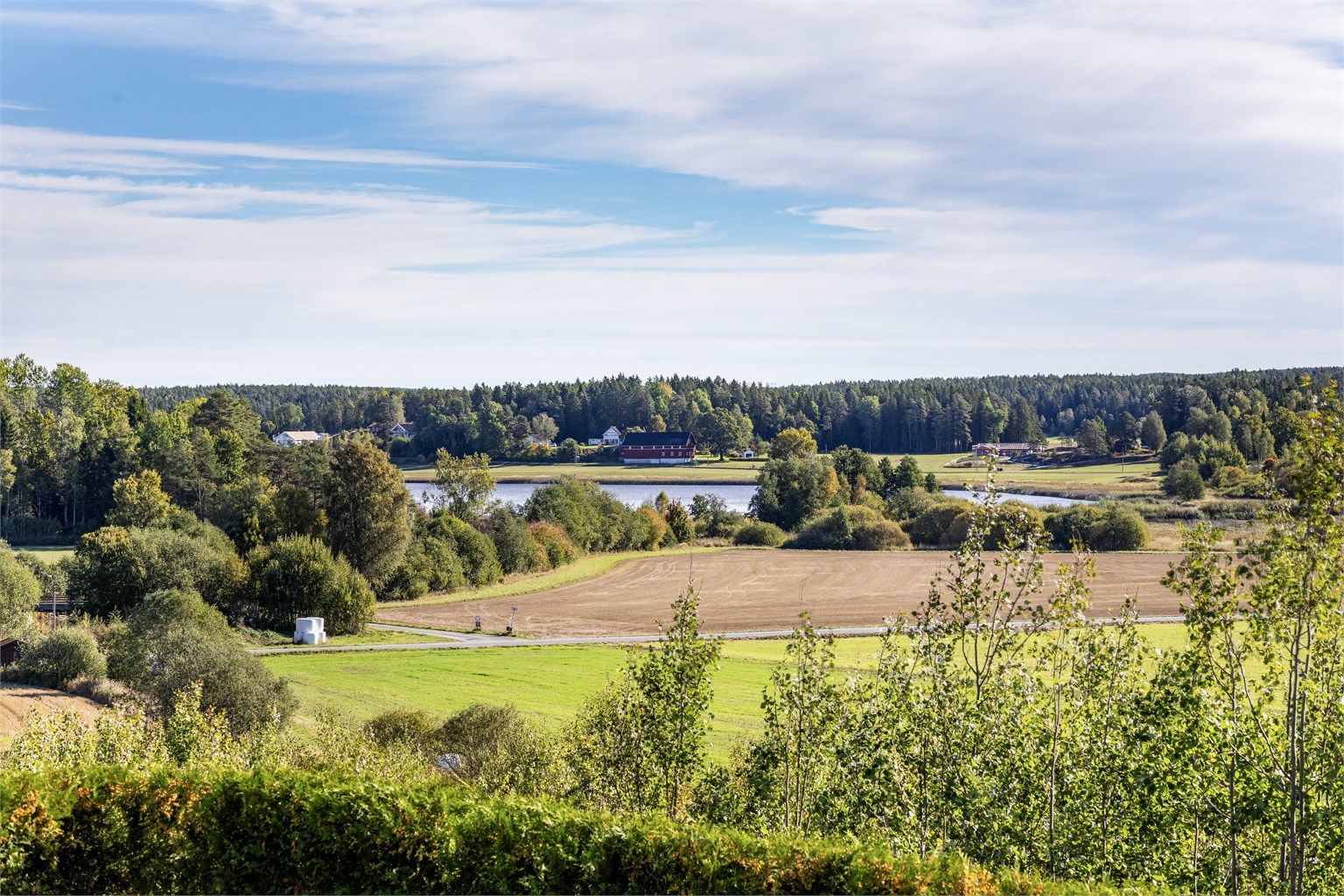 Ute som inne sees vidstrakt utsikt over åkre, skog og vann.