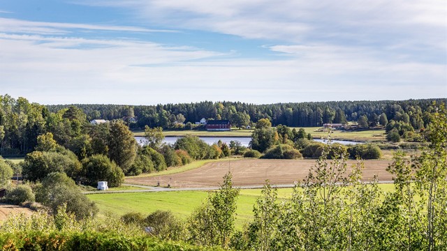 Ute som inne sees vidstrakt utsikt over åkre, skog og vann.