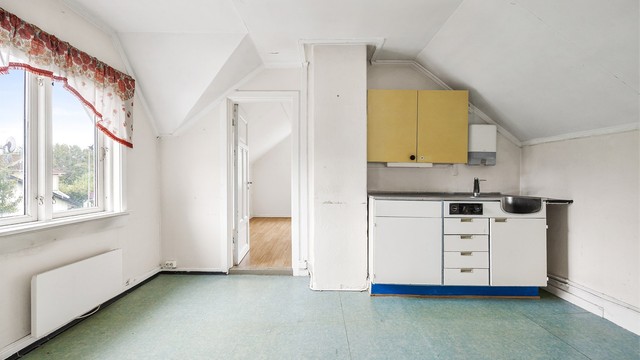Kjøkkeninnredning fra ukjent årstall med glatte fronter. Benkeplaten er av rustfritt stål og har nedfelt oppvaskkum.