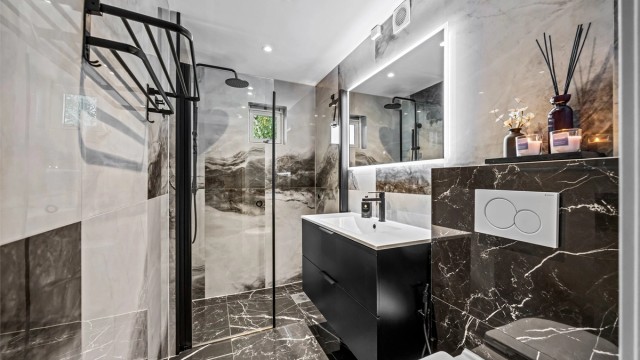 Badet er utstyrt med vegghengt servantskap, dusjnisje med glassdører og regnfallsdusj, samt vegghengt toalett med innebygd sisterne.
