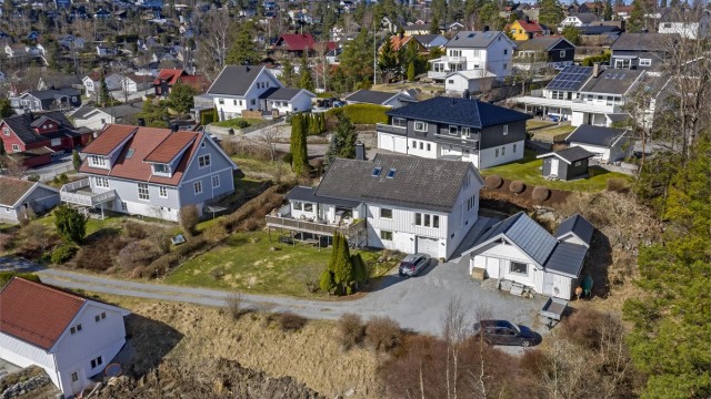 Innholdsrik eiendom med stor tomt (1.439 kvm) - tilliggende garasje i boligen samt frittstående garasje/verksted - romslig gårdsplass