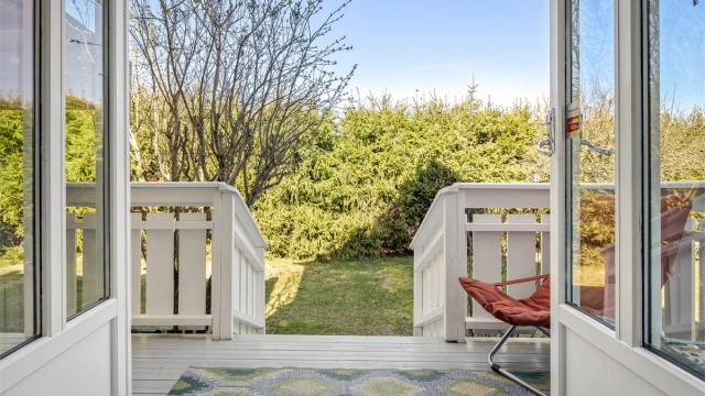 Fra balkongen ved spisestuen er det trapp ned til den store plattingen og hagen.