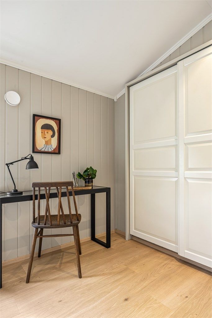 I det ene rommet er det en plassbygget skyvedørsgarderobe i hvit og profilert utførelse.