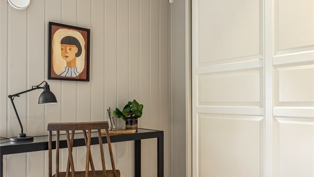 I det ene rommet er det en plassbygget skyvedørsgarderobe i hvit og profilert utførelse.