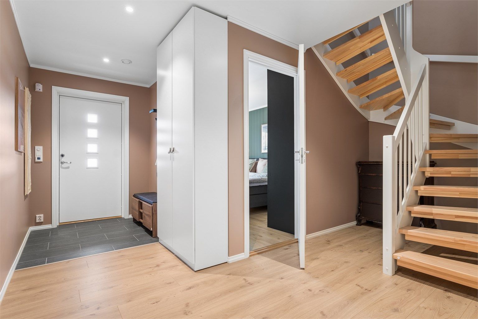 Den romslige entréen tar deg godt imot, med flislagt gulv, gulvvarme og garderobeskap.