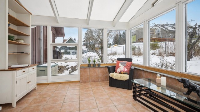 Dette rommet er uisolert, men har flislagt gulv med varmekabler og god plass til møblering – et flott ekstra oppholdsrom som kan brukes store deler av året.