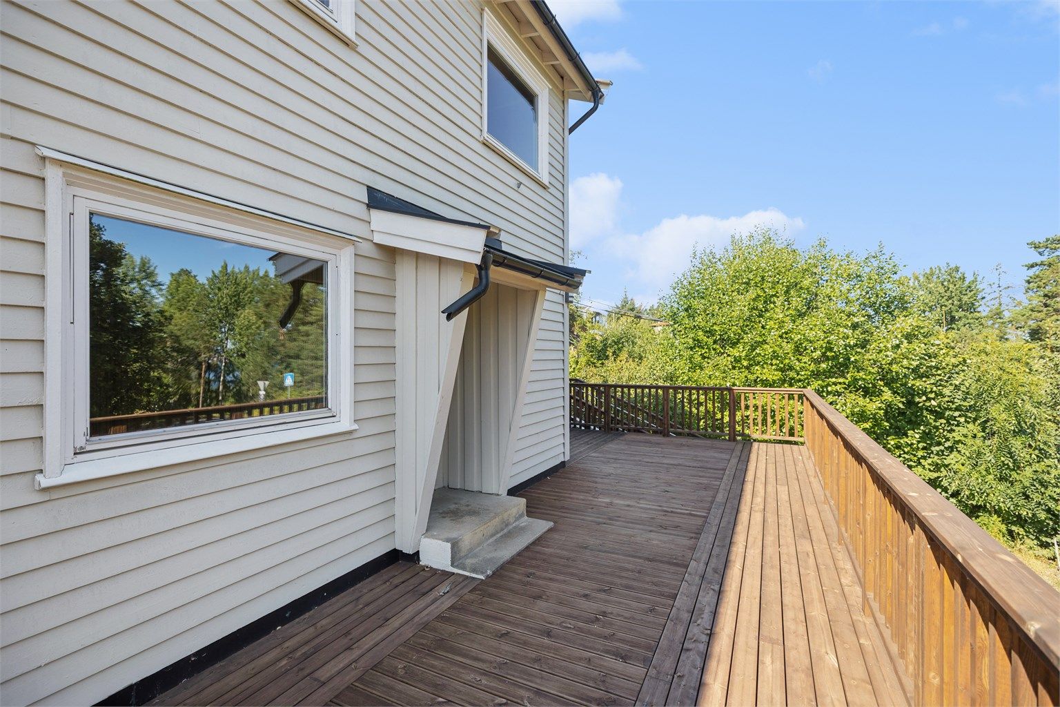 Adkomst til boligen via trapp til takoverbygget inngangsparti. Her er det mulig å sette ut en liten sittegruppe for å nyte morgenkaffen.