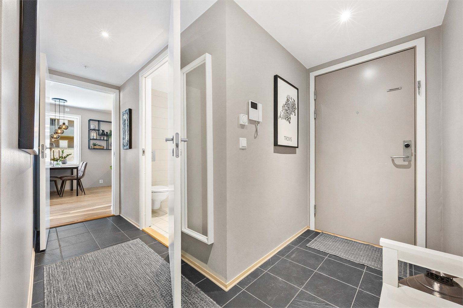 Innbydende entré med flislagt gulv og adkomst til badet og den sosiale sonen.