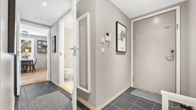 Innbydende entré med flislagt gulv og adkomst til badet og den sosiale sonen.