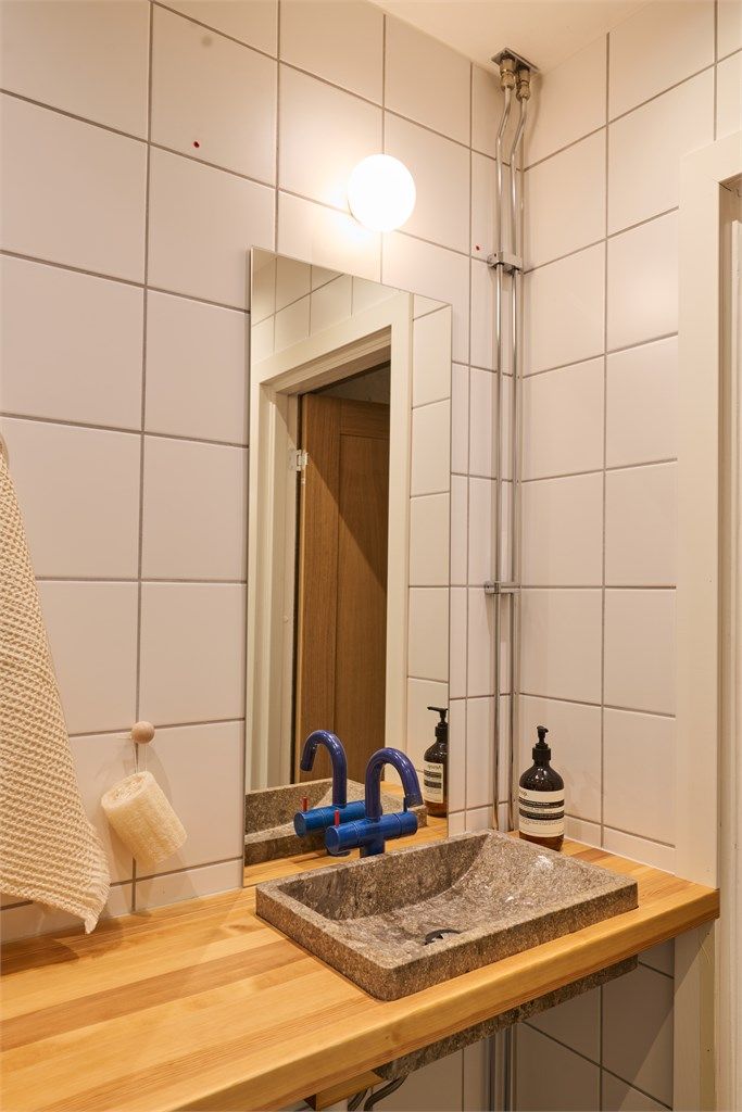 Badet har dusjhjørne med glassdører, vegghengt toalett og opplegg for vaskemaskin. Vaskemaskin medfølger.