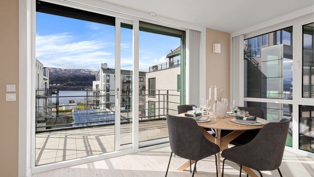 Stor skyvedør i glass fra 2015 visker ut skillet mellom stuen og balkongen. Det er også montert lameller