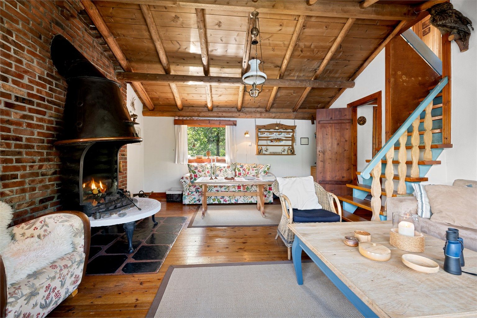 Det er åpen peis i stuen som gir en lun og hyggelig atmosfære. Trapp fra stue til soverom i loftsetasjen