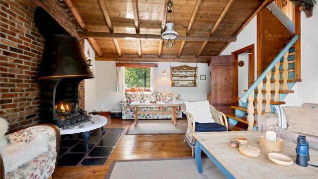 Det er åpen peis i stuen som gir en lun og hyggelig atmosfære. Trapp fra stue til soverom i loftsetasjen