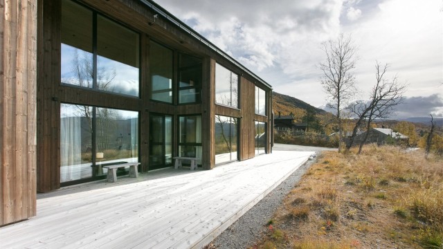 Treterrassen strekker seg rundt tre sider av fritidsboligen og har lett adkomst til terreng og tomten forøvrig