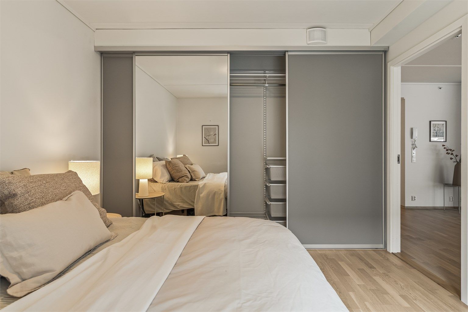 En romslig skyvedørsgarderobe med speilfronter gir rikelig med oppbevaringsplass.