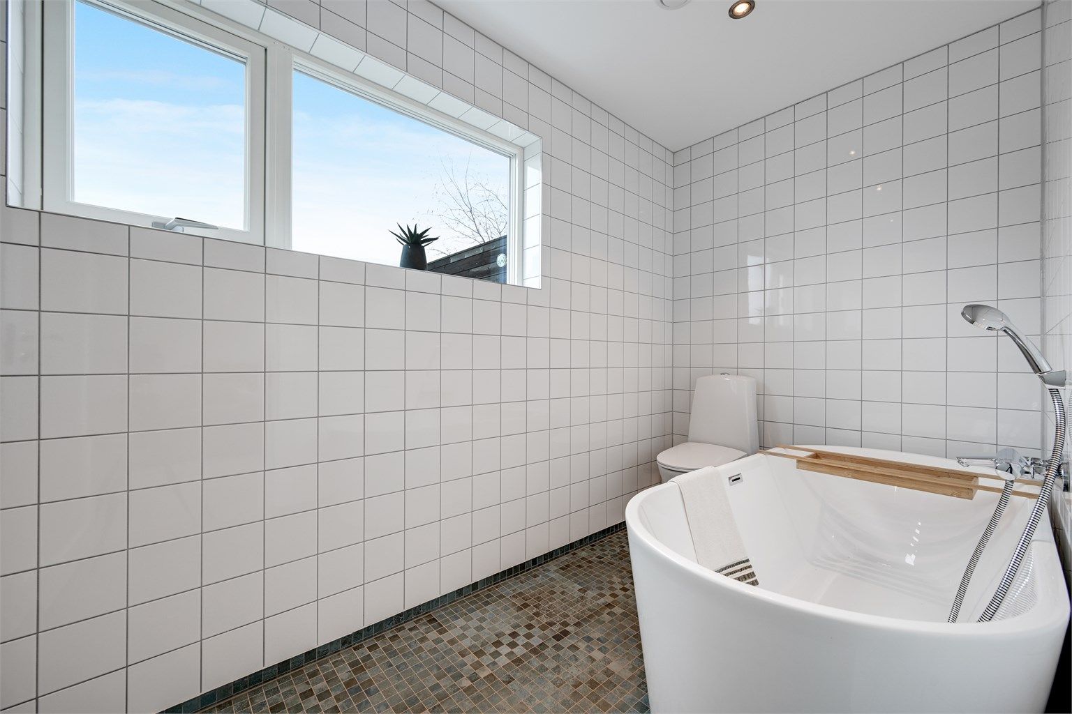 Badet i denne etasjen er helfliset, har gulvvarme og et frittstående badekar.