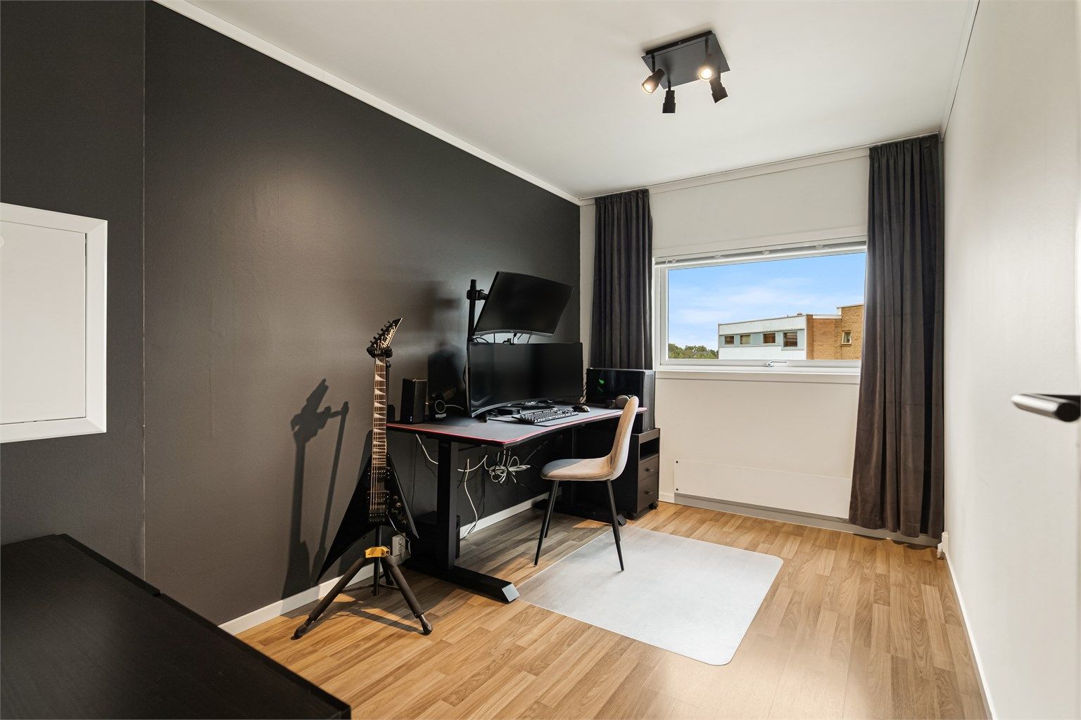 Soverom nummer to er innredet som kontor, med laminat på gulv og malte slette flater.